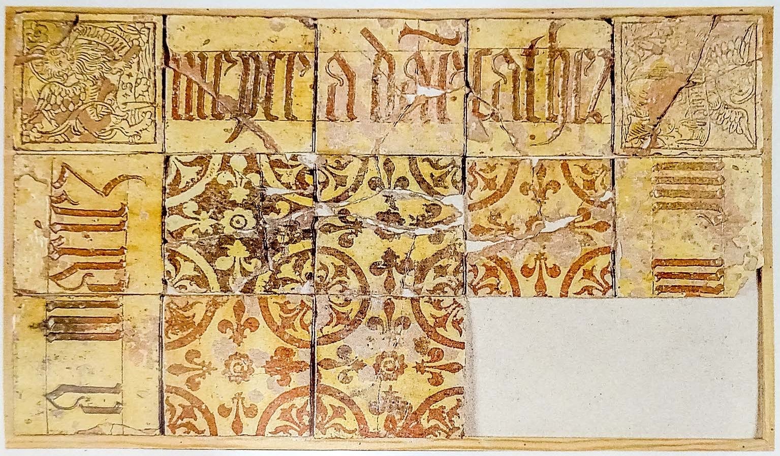 Fragment van een grafplaat van geglazuurde tegels met gotische tekst en versierde hoektegels.