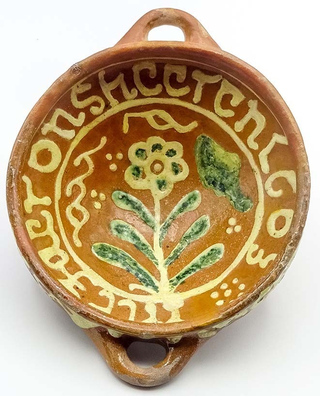 Kom met een gele bloem in het midden en rondom de tekst INT JAER ONS HEEREN 1603.