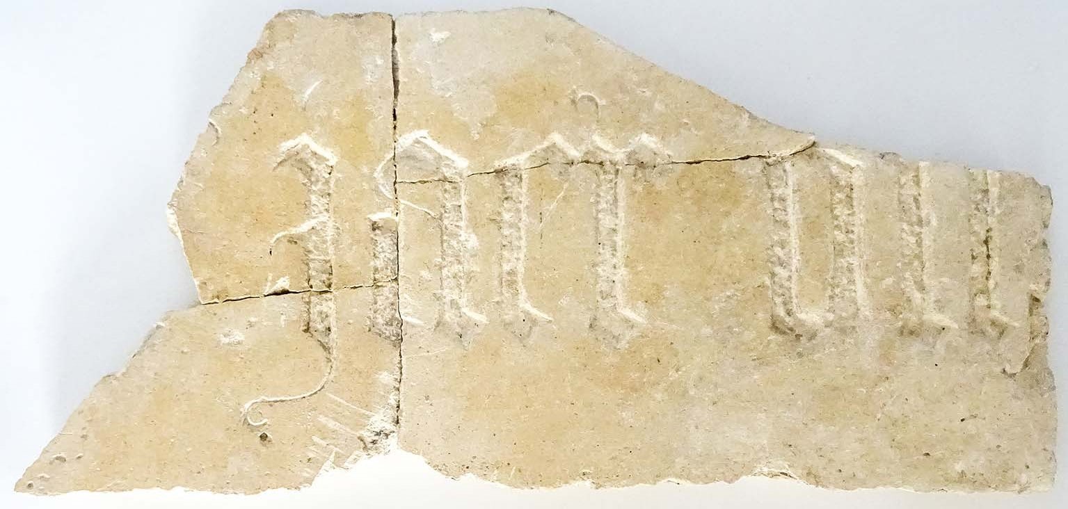 Strook kalksteen met de uitgehakte letters JAER ON.