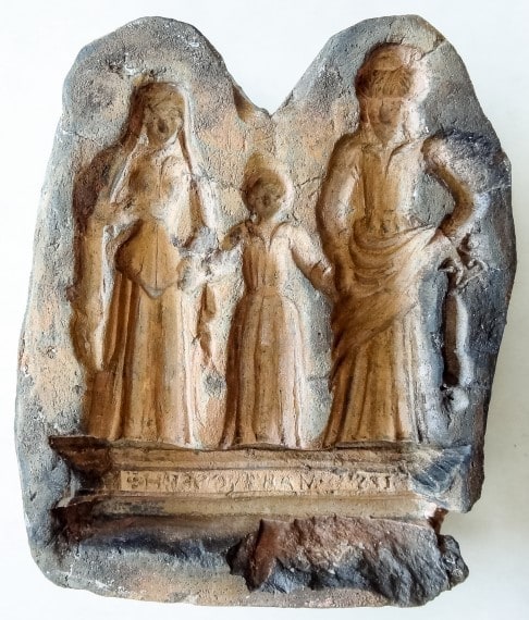 Roodbakkende mal met in negatief het Christuskind tussen Maria en Joseph.