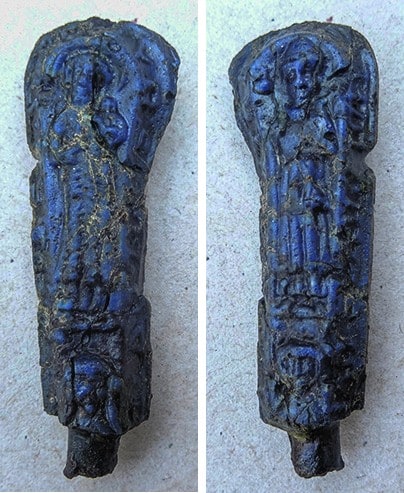 Voor- en achterkant van een blauw glazen mesheft met reliëffiguren.