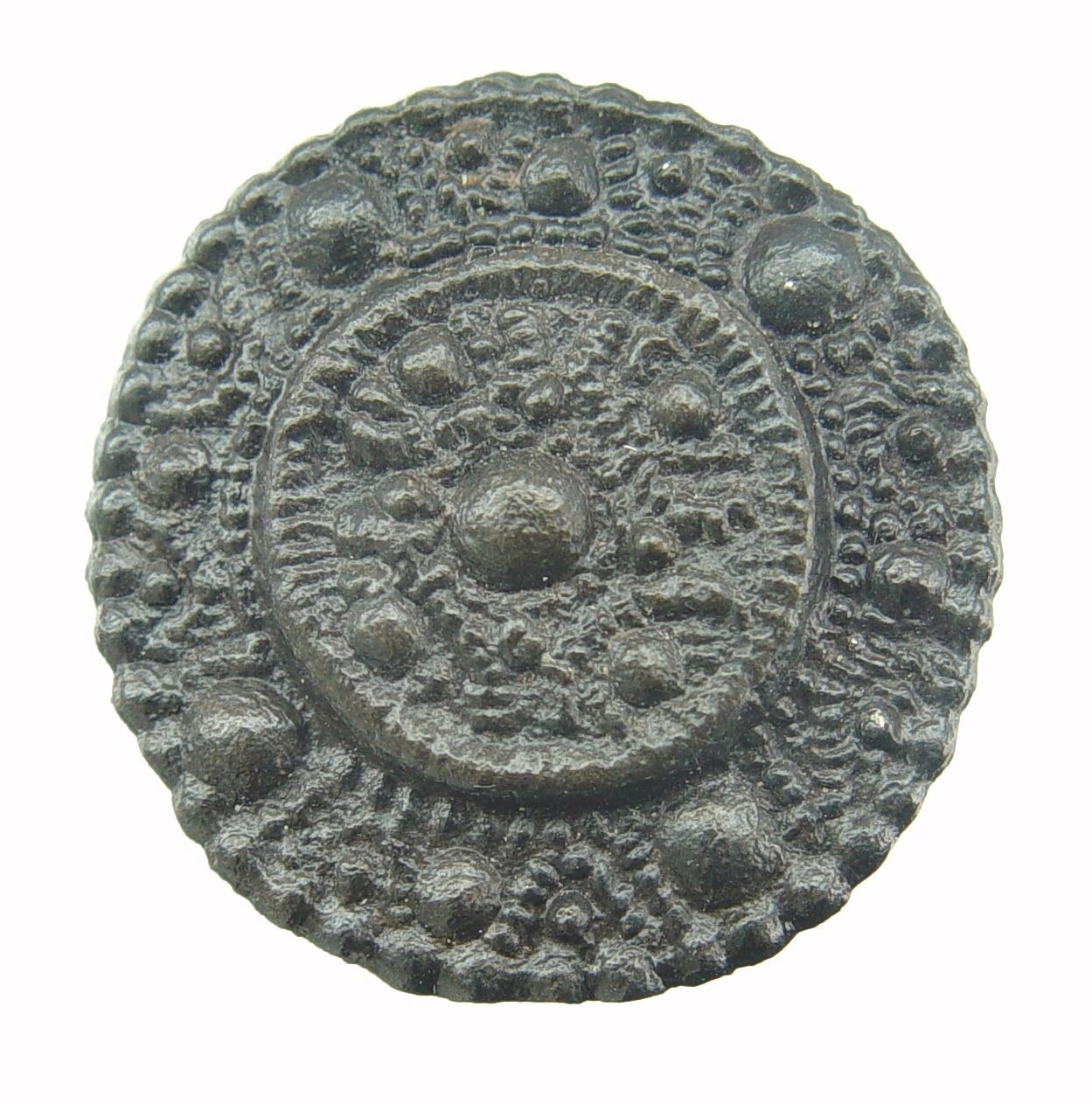 Ronde donkere fibula met een kring van bolletjes en fijn korrelwerk rond een verhoogd midden.